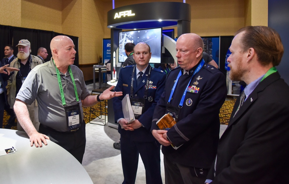 Maj. Gen. Stephen Purdy is briefed on AFRL space technology programs at Space Symposium in Colorado Springs.