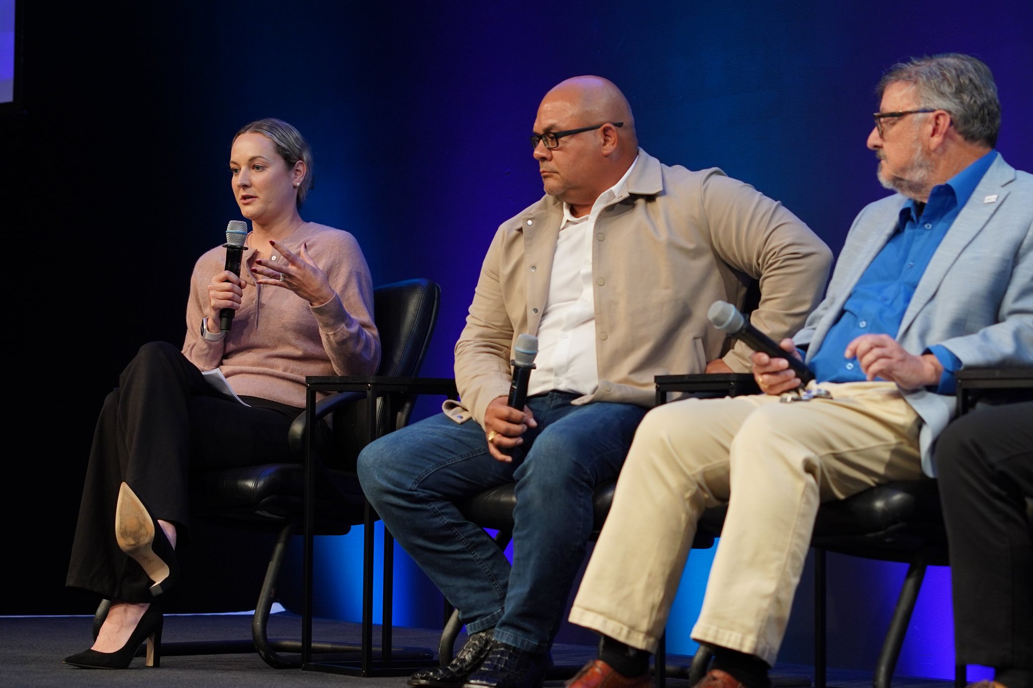 Scout Space Chief Product Officer Courtney Sayles speaks into a microphone on the space control panel at the MilSat Symposium at Silicon Valley Space Week 2026.