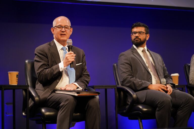 Scott Patrick of NTIA speaks into a microphone while seated on stage at Silicon Valley Space Week 2026