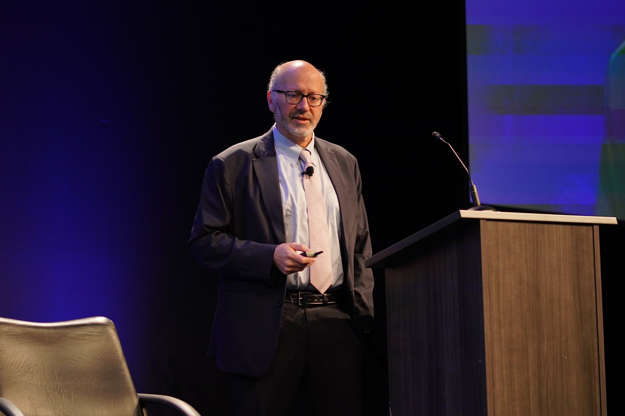 Ron Epstein of Bank of America Securities speaks beside a podium during the opening keynote of Silicon Valley Space Week 2026 at the Computer History Museum.